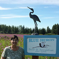 Deb with Blue Heron signage